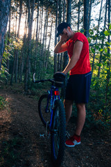 Fototapeta premium Portrait of a handsome mountain biker drinking water while wearing his baseball cap (hat).