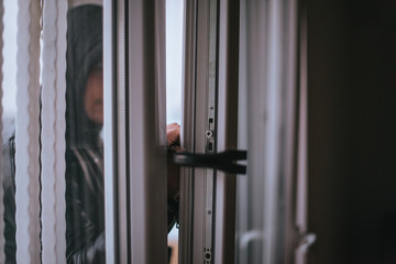 A thief trying to get into a house by the backdoor