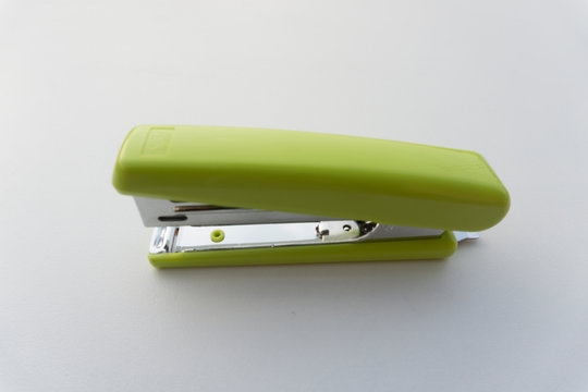 Green stapler isolated on white background.