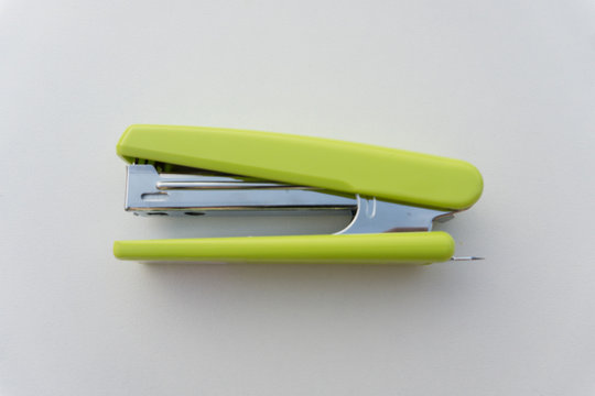 Green stapler isolated on white background.
