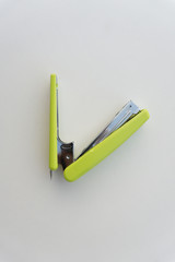 Green stapler isolated on white background.