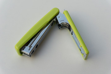 Green stapler isolated on white background.