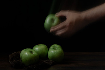 Green apples, cider on wood with black background and space for writing.