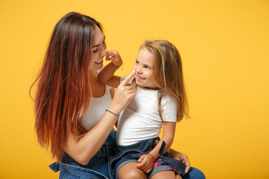 Woman in light clothes have fun with cute child baby girl 4-5 years old. Mommy little kid daughter isolated on yellow background studio portrait. Mother's Day love family parenthood childhood concept. - Powered by Adobe