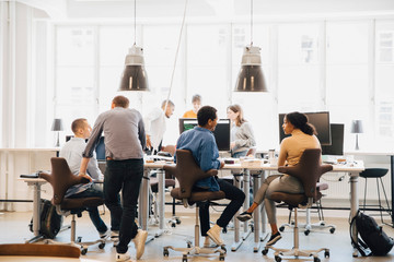 Male and female computer programmers working at desk in creative workplace