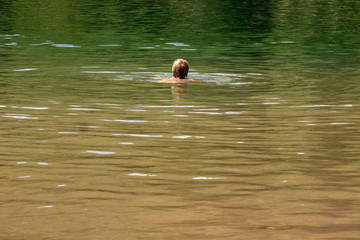 woman swimming in natural lake