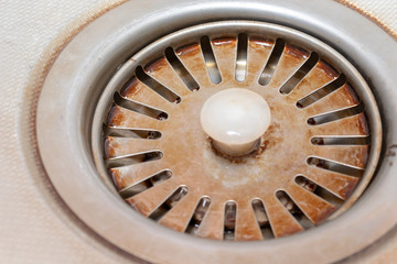 Old rusty calcified drain hole in the kitchen sink with limescale and scurf scum