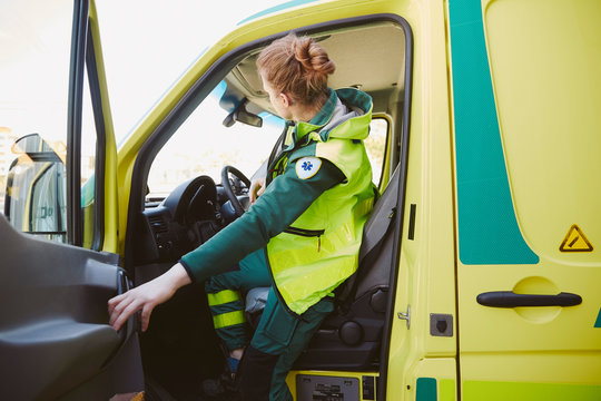 Female paramedic closing door of ambulance