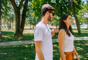 Fototapeta premium Summer walk. Young happy couple on a walk in the park
