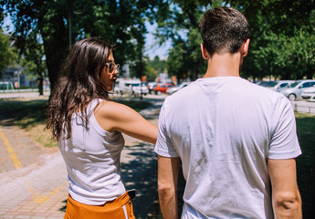 Happy teenage couple walking at summer park