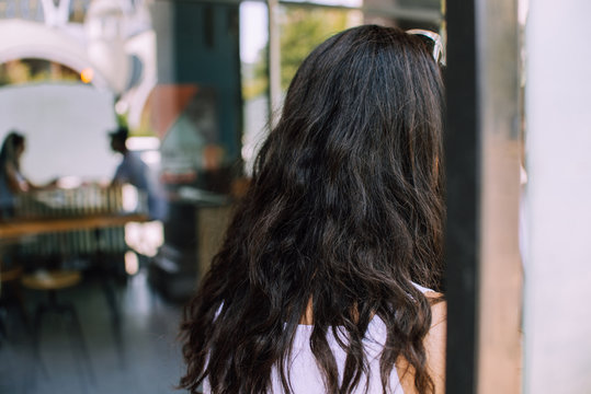 Back view of a woman with long curly hair