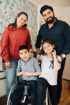 Portrait of smiling parents with children at home