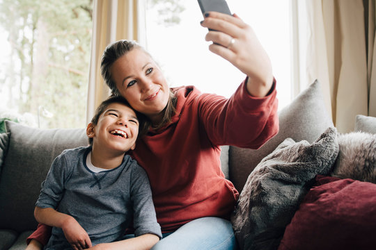 Mother taking selfie with autistic son at home