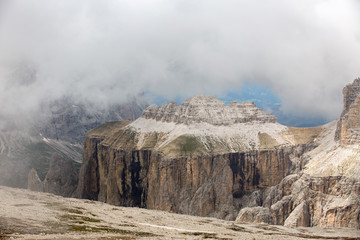Fototapeta na wymiar Piz Ciavazes on the Sella in the Dolomites with the Langkofel, Sassolungo in the Background. Clouds covering the Lang Kofel, Sasso Lungo. View from Piz Pordoi