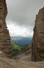 Looking down from Sass Pordoi to the Passo Pordoi in the Dolomites with Rocks on the left and right side.
