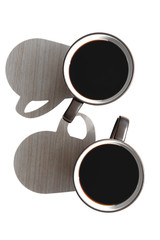 two large dark circles with light walls inside and dark brewed coffee standing on a light table in direct sunlight and casting a shadow