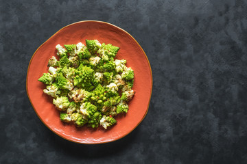 Baked cabbage romanesco with spices on a black background. Top view. 
