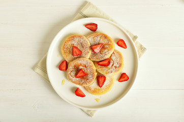 Cottage cheese pancakes with strawberry slices and honey