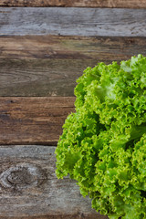 Head of green fresh salad on an old rough wooden surface, healthy eating concept, selective focus