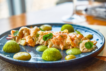Tartar salmon with green sauce on the plate