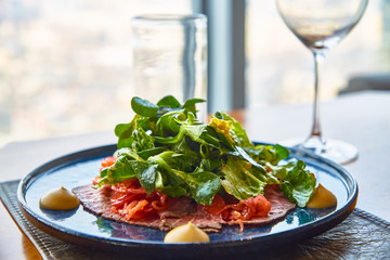 Roast beef with green salad and mustard is on the plate