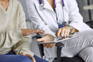 female doctor talking to a patient on a tablet