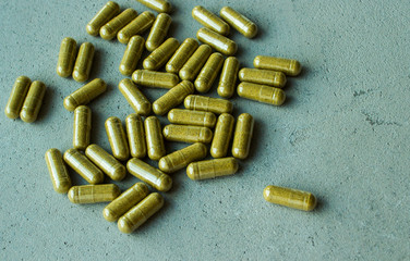 biologically active food supplement vitamin capsule pills scattered on a gray concrete background