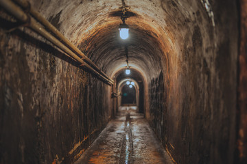 long dark narrow underground tunnel with lighting