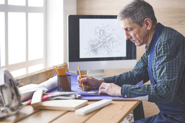 Engineer carpenter working on laptop and sketching project