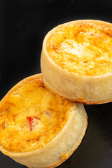 Two Small Fresh bakes Quiches on a Small Black Slate Tray.
