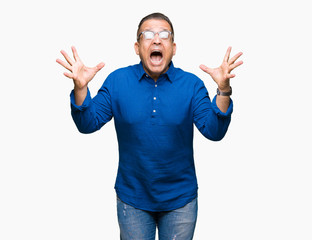 Middle age arab man wearing glasses over isolated background celebrating crazy and amazed for success with arms raised and open eyes screaming excited. Winner concept