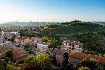 Fototapeta na wymiar View on the houses, vineyards and hills of the historic Italian village of Cossignano