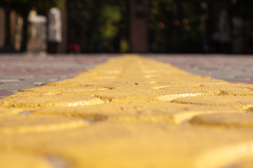 Yellow line marking on the paving stones. Solid line. Selective focus.
