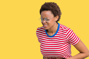 Beautiful young african american woman wearing glasses over isolated background with hand on stomach because nausea, painful disease feeling unwell. Ache concept.