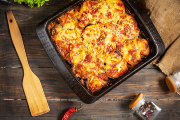Baked eggplant with cheese on a wooden table. Parmigiana melanzane. Top view. Italian cuisine.