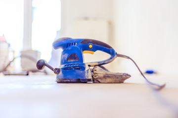 Renovating at home: sander tool for refreshing and grinding the wooden parquet floor