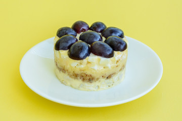 The legendary Tiffany layered salad with grapes, chicken and cheese on the yellow background.