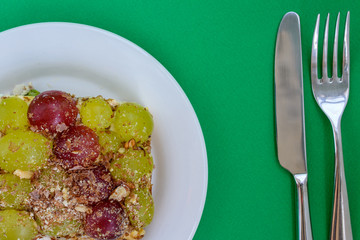 The legendary Tiffany layered salad with grapes, chicken and cheese on the green background.