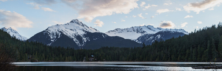 Lake with cottages and snowy mountains in background