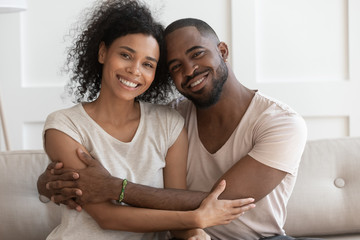 Happy young smiling cuddling african american family portrait.