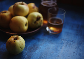 apple juice and wicker basket full of apples amd pears over summer nature background