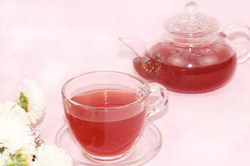 An isolated cup of flower tea and a teapot on a light background, selective focus. Morning tea for energy, the concept of a healthy diet and diet