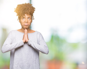 Beautiful young african american woman over isolated background begging and praying with hands...