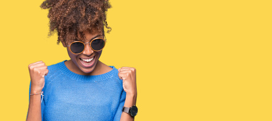 Beautiful young african american woman wearing sunglasses over isolated background very happy and...