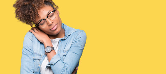 Beautiful young african american woman wearing glasses over isolated background Hugging oneself happy and positive, smiling confident. Self love and self care