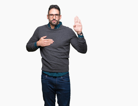 Young handsome man wearing glasses over isolated background Swearing with hand on chest and open palm, making a loyalty promise oath