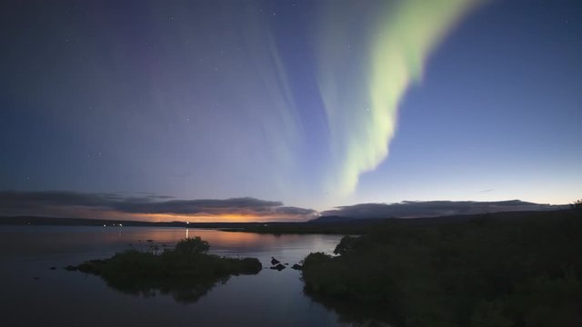 Aurora borealis at dusk reflecting in calm water Thingvellir lake Iceland.mov