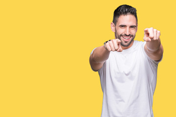 Fototapeta premium Handsome man wearing white t-shirt over yellow isolated background Pointing to you and the camera with fingers, smiling positive and cheerful