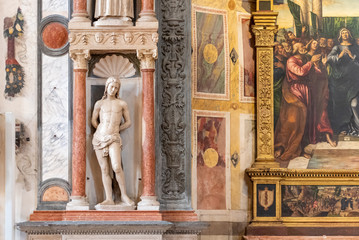 Detail of marble statue of semi naked man decorating catholic church interior in Italy