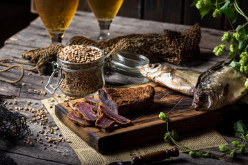 Beer still life with fishes and bottles. Meat basturma. October fest. Oktoberfest. Dry fish and dry meat. Country meal